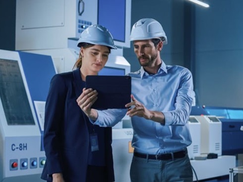 A female engineer looking at a tablet held by a fellow male engineer
